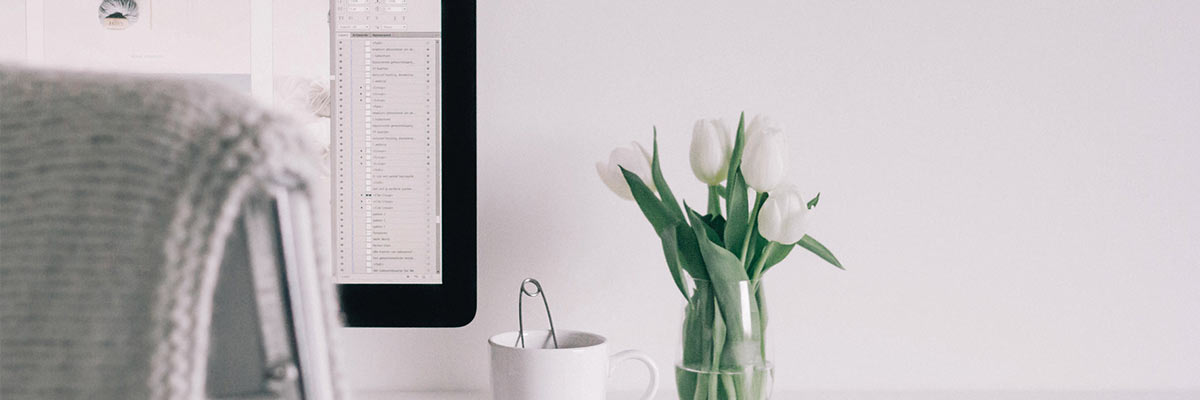 a computer on a desk with flowers