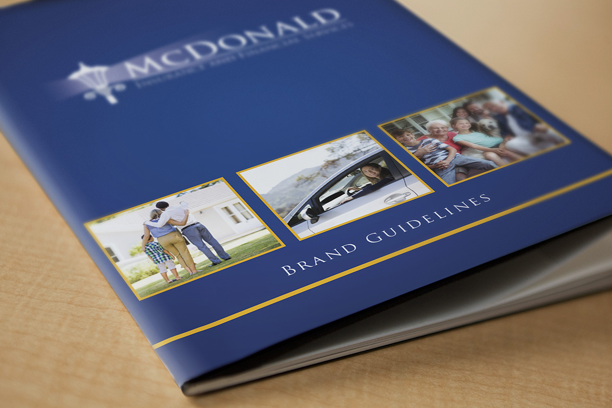 Close up of brand standards guide cover that has McDonald Insurance logo and text that reads 'brand guidelines'