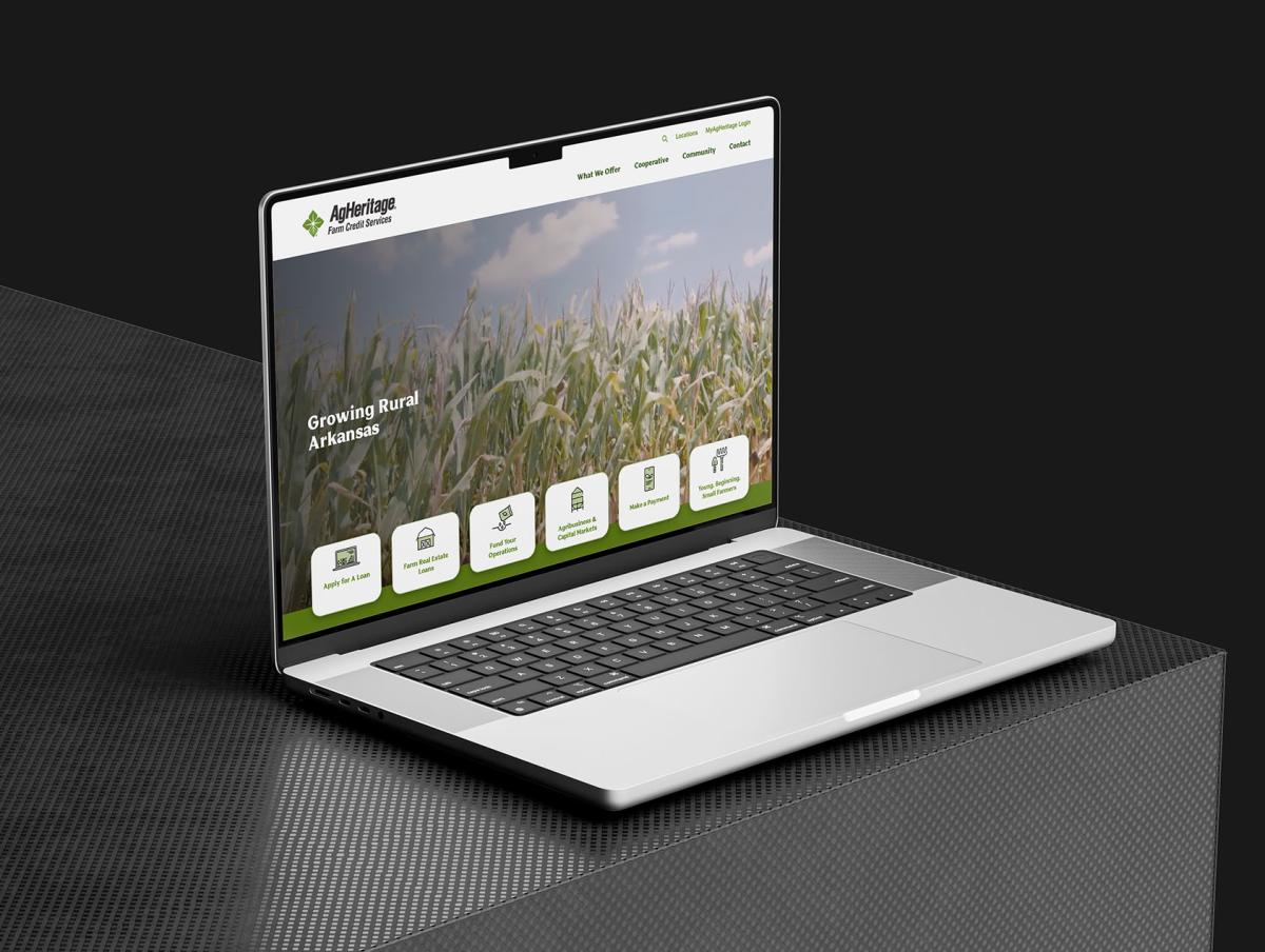 Agheritage website mockup on laptop sitting on black table 