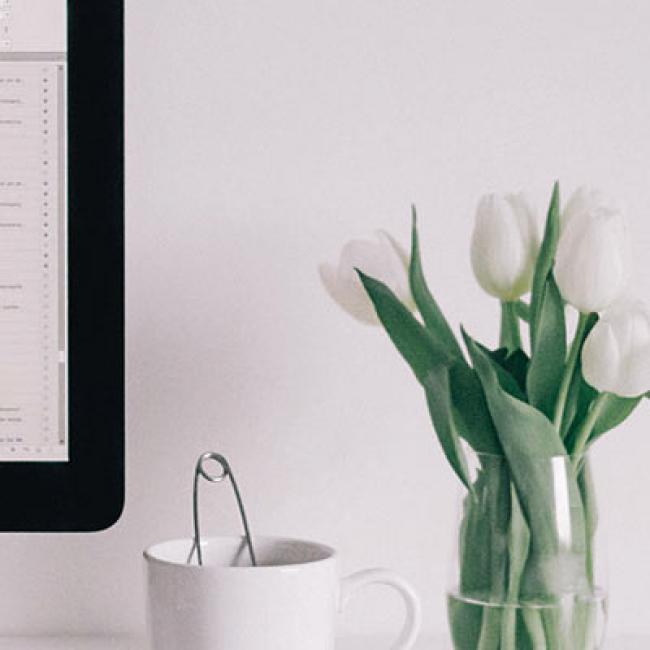 a computer on a desk with flowers