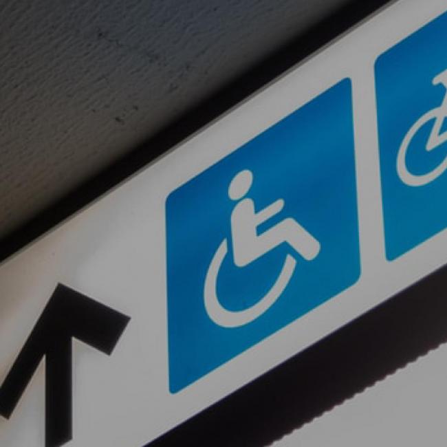 Image of an up arrow next to a blue handicap sign on a lighted sign